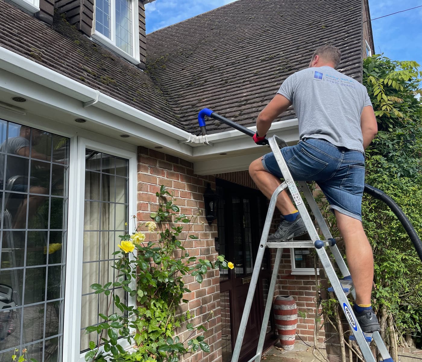 Moss and debris being cleared from a house gutter